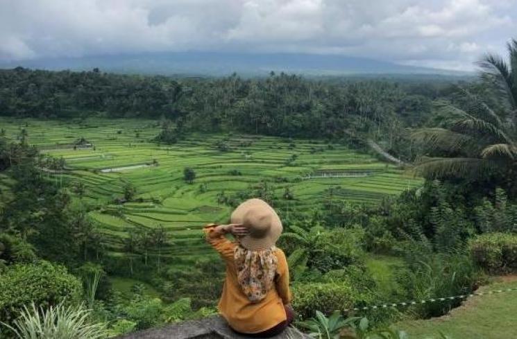 Seorang pengunjung menikmati keindahan alam Bali dari Mahagiri Restaurant & Resort. (foto: Putu Reza)