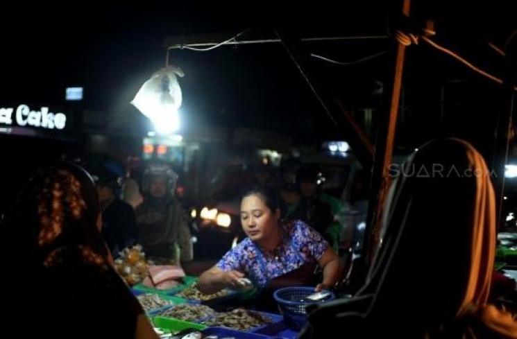 Pedagang ikan menjajakan daganganya untuk berjualan di Jalan Kramat Jati, Jakarta Timur, Senin (2/12). [Suara.com/Alfian Winanto]